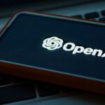 a cell phone sitting on top of a laptop computer