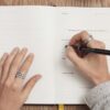 person writing on a book
