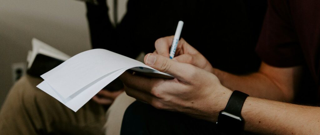 man writing beside man