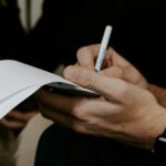 man writing beside man